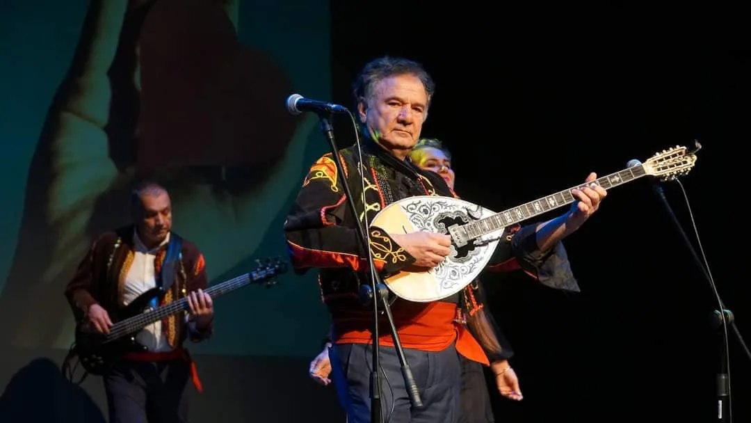 Mythos bouzouki player in ornate costume on stage